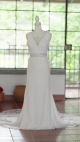 Long-white-wedding-dress-displayed-on-mannequin-in-country-house-room