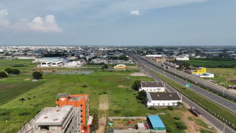 Wide-angle-shot-of-Amaravathi’s-countryside-road-surrounded-by-small-building-with-greenery