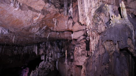 Eine-Ausgedehnte-Höhle-Weist-Eine-Decke-Auf,-Die-Mit-Zarten-Stalaktiten-Und-Massiven-Felsformationen-Geschmückt-Ist