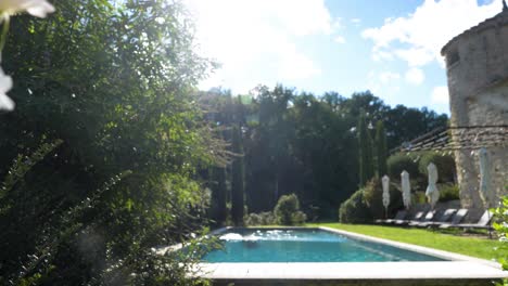 A-beautifully-decorated-garden-with-vibrant-white-flowers-surrounds-a-serene-swimming-pool-at-Maison-Goult,-France