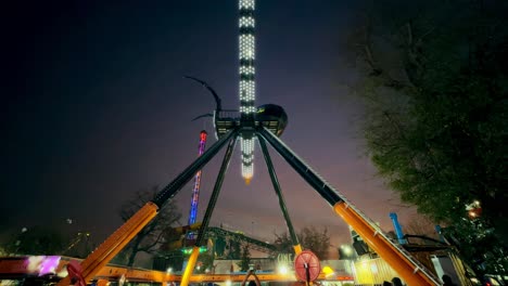 Wide-angle-view-of-the-Spider-ride-at-night-at-Fantasilandia-amusement-park,-Santiago,-Chile