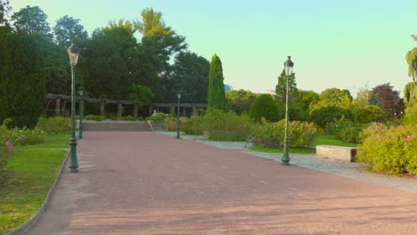 Erleben-Sie-Einen-Ruhigen-Spaziergang-Entlang-Der-Wege-Des-Parks-Des-Goldenen-Kopfes-In-Lyon,-Während-Goldene-Farbtöne-Den-Himmel-An-Einem-Ruhigen-Abend-Erfüllen