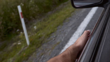 Una-Mano-Golpea-El-Borde-De-La-Ventanilla-De-Un-Coche-Al-Ritmo-De-La-Música,-Balanceándose-Mientras-El-Coche-Se-Mueve.