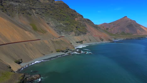 Journey-over-Iceland’s-majestic-terrain-as-the-drone-glides-above-the-shimmering-ocean,-revealing-the-captivating-interplay-of-land-and-sea-in-this-breathtaking-natural-wonder