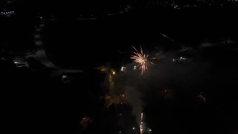 Feuerwerk,-Das-Den-Dunklen-Himmel-über-Einer-Stadt-Mit-In-Der-Ferne-Leuchtenden-Lichtern-Erhellt