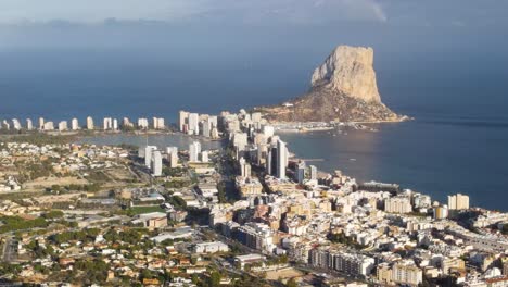 Costa-De-Calpe-Y-Formación-Rocosa-Del-Peñón-De-Ifach-En-Un-Día-Soleado,-Vista-Aérea