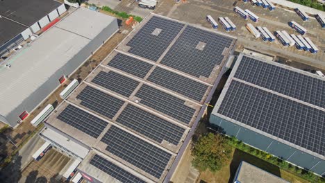 High-aerial-of-large-industrial-buildings-with-photovoltaic-solar-panels-on-the-rooftops