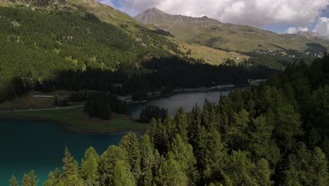 Eine-Ruhige-Luftaufnahme-über-Den-Silvaplanersee-In-Graubünden,-Schweiz,-Umgeben-Von-üppigen-Wäldern-Und-Hohen-Bergen,-Die-Die-Ruhe-Der-Natur-Und-Die-Schönheit-Der-Alpinen-Landschaften-Einfängt