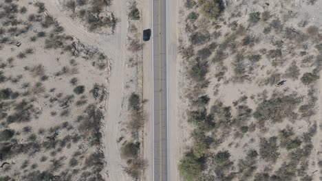 Aerial-view-of-vehicle-traveling-along-tourist-route-40-in-arid-Cafayate-valley