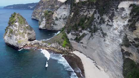 Drone-flying-along-a-cliff-with-a-beach