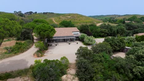 Luftaufnahme-Eines-Von-üppiger-Natur-Umgebenen-Hauses-Im-Domaine-Sainte-Colombe,-Frankreich,-Das-Eine-Harmonische-Mischung-Aus-Architektur-Und-Natürlicher-Schönheit-Zeigt