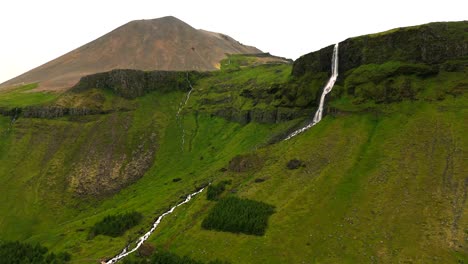 Begleiten-Sie-Uns-Auf-Einem-Abenteuer-Aus-Der-Luft-über-Bjarnarfoss-Und-Erleben-Sie-Das-Majestätische-Zusammenspiel-Von-Berg-Und-Wasserfall,-Ein-Wahrer-Beweis-Für-Islands-Beeindruckende-Naturwunder.