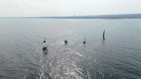 Four-sailboats-on-restful-calm-waves-of-Baltic-Sea,-Gdansk-Bay,-Poland-aerial-panorama