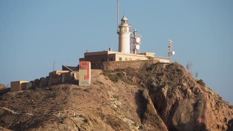 Leuchtturm-Am-Cabo-De-Gata,-Die-Kamera-Neigt-Sich-Nach-Unten,-Um-Den-Nahe-Gelegenen-Strand-Zu-Zeigen