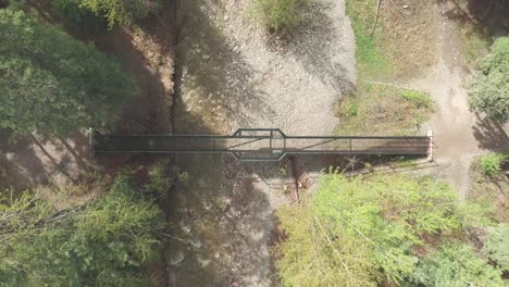 Static-drone-shot-of-a-bridge-in-the-forest