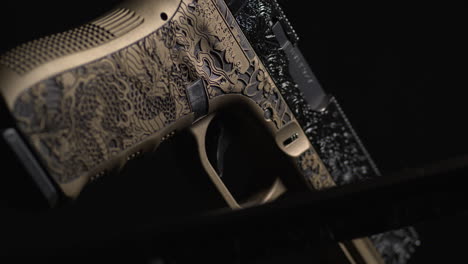 Black-Knife-Blade-Showcased-Against-Burnt-Bronze-Coated-Glock-Gun-with-Laser-Engraving