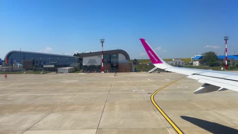 Plane-window-view-takeoff-Suceava-Airport-in-Romania,-fly-airplane-wing-view