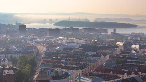 Sunrise-aerial-trucking-view-over-Frogner-borough-toward-Oslofjord,-Oslo,-Norway