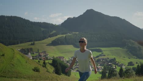 A-woman-hikes-through-scenic-mountain-landscapes-in-Berwang,-Austria-on-a-sunny-day