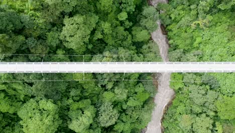 Stunning-top-down-aerial-footage-of-a-pedestrian-suspension-bridge-spanning-a-river-in-the-Himalayas