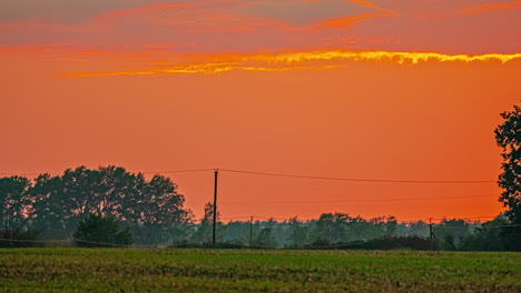 Massive-red-sunset-over-rural-landscape-of-Latvia,-time-lapse-view