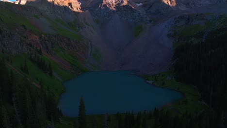 Lower-Blue-Lake-sunset-dusk-Mount-Sneffels-Wilderness-Ridgway-Telluride-Colorado-aerial-drone-golden-hour-shaded-peaks-San-Juan-Rocky-Mountains-Uncompahgre-National-Forest-blue-sky-backwards-pan-up