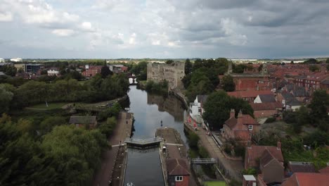 Aerial-Drone-footage-starting-behind-a-River-Boat-in-Newark-Town-Lock-that-moving-up-and-forward-over-to-Newark-Castle-and-Gardens-and-panning-down-over-the-Castle-and-Gardens