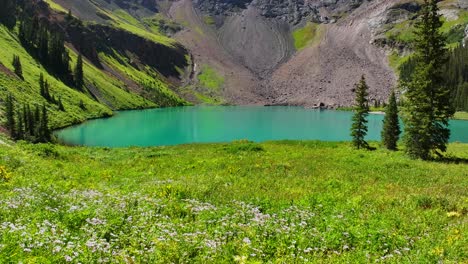 Lower-Blue-Lake-Mount-Sneffels-Wilderness-beautiful-sunny-morning-Ridgway-Telluride-Colorado-aerial-drone-forward-pan-motion-San-Juan-Rocky-Mountains-Dallas-Range-wildflowers-blue-sky-hiking-trails