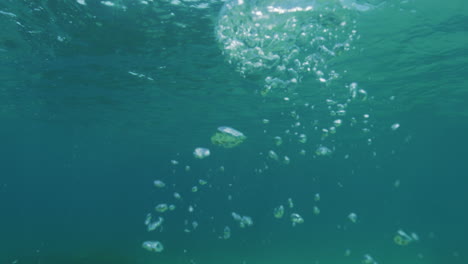 Slow-motion-of-an-underwater-photographer-blowing-bubbles-in-clear-Australian-Pacific-Ocean-waters