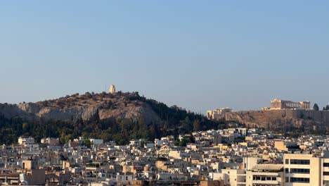 Lofos-Philapappou-and-Acropolis-in-Athens-seen-in-the-distance,-summer-time