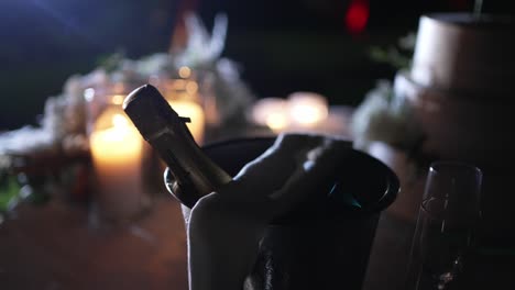 Champagne-bottle-in-bucket-with-glowing-candles,-creating-a-romantic-evening-ambiance