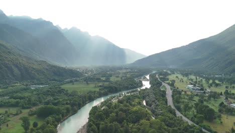 Toce-river-surrounded-by-mountains,-sunny-and-foggy-day-over-the-mountains