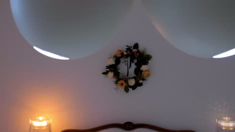 Indoor-setting-of-a-bedroom-with-lights-on-and-flower-decorations-on-the-wall-at-Maison-Vias,-France