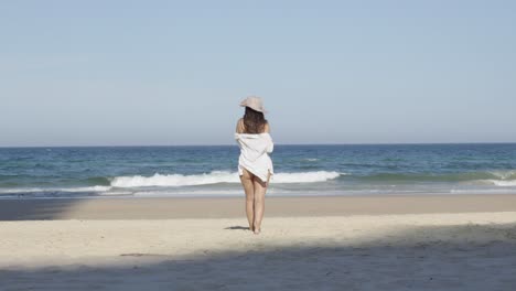 Girl-at-the-beach,-Beautiful-young-woman-beachwear-walking-toward-ocean