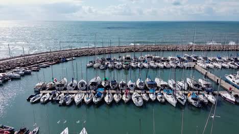 Luftaufnahme-Des-Hafens-Von-Tel-Aviv-Mit-Verankerten-Segelbooten-An-Einem-Sonnigen-Tag,-Atemberaubende-Küstenlandschaft,-Überführung