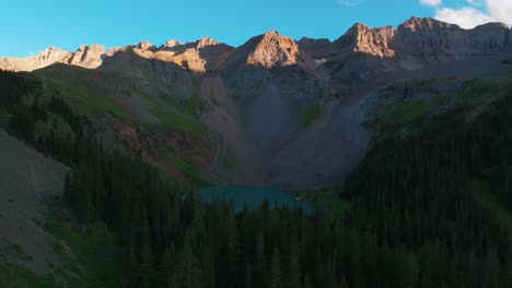 Sunset-dusk-Lower-Blue-Lake-Mount-Sneffels-Wilderness-Ridgway-Telluride-Colorado-aerial-drone-golden-hour-shaded-peaks-San-Juan-Rocky-Mountains-Uncompahgre-National-Forest-blue-sky-forward-pan-up