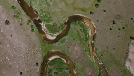 Vista-Aérea-Desde-Arriba-Del-Sendero-Big-Sandy,-En-El-área-Silvestre-De-Wind-River,-Wyoming,-Con-Exuberantes-Llanuras-Verdes,-Ríos-Serpenteantes-Y-Montañas-Distantes