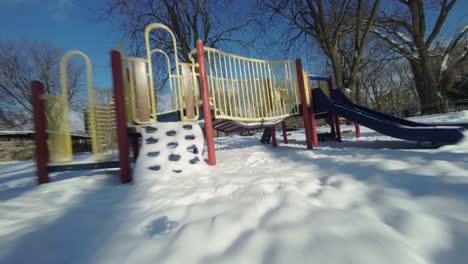 Drone-Fpv-view-across-various-obstacles-rides-in-a-playground-during-winter