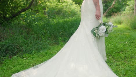 Novia-Posando-En-El-Bosque-Sosteniendo-Un-Ramo-De-Flores-Mientras-La-Cámara-Se-Mueve-Hacia-Arriba-En-Cámara-Lenta