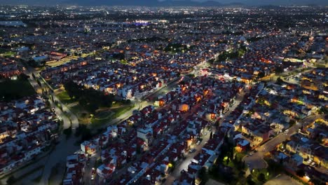 Drone-shot-at-dusk-over-a-middle-class-neighborhood-midweek-observing-houses-and-the-industrial-area-of-Cuautitlán-Izcalli,-State-of-Mexico,-part-of-the-Mexico-City-metropolitan-area