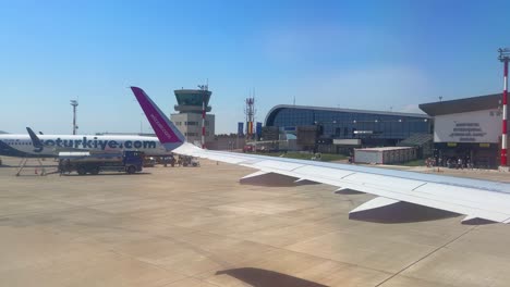 Plane-window-view-takeoff-Suceava-Airport-in-Romania,-fly-airplane-wing-view