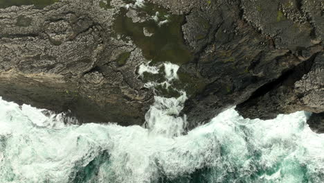 Aerial-birdseye-over-sea-waters,-tilt-up-revealing-Lake-Sorvágsvatn,-Faroe-Islands