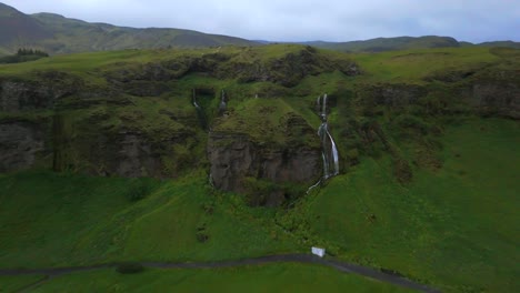 The-drone-reveals-Seljalandsfoss-in-all-its-glory,-showcasing-the-cascading-water-against-a-backdrop-of-dramatic-cliffs