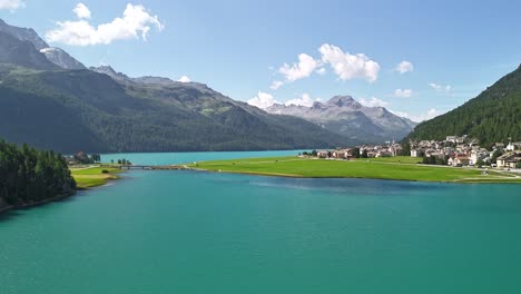 Zeitraffer-Luftaufnahme-Des-Silvaplanersees-In-Graubünden,-Schweiz,-Klares-Wasser-Und-Umliegende-Berge,-Ein-Ruhiges-Wohngebiet-Entlang-Des-Ufers,-Wo-Natur-Und-Menschliche-Präsenz-Verschmelzen