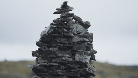 A-stone-cairn-made-of-dark-jagged-pointy-rocks-in-the-gloomy-landscape