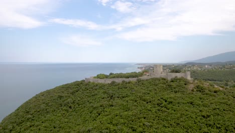 Vista-De-Drones,-Castillo-En-La-Cima-De-La-Colina-Junto-Al-Mar