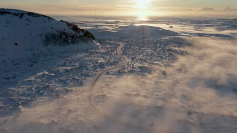 Abgelegene-Arktische-Straße-In-Vulkanischem-Gelände,-Bedeckt-Mit-Schnee-Und-Leichtem-Nebel,-Luftaufnahme