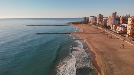 Slow-calm-waves-rolling-in-on-empty-spanish-beach,-El-Campello,-Costa-Blanca
