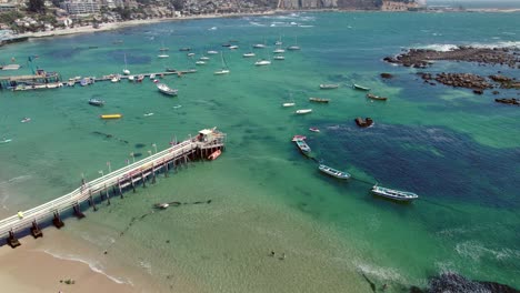 Aerial-orbit-establishing-of-boats-parked-at-the-dock-of-Pejerrey-beach,-Algarrobo,-Chile