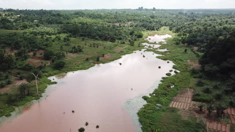 Aerial-on-brown-irrigation-lac-farms-and-jungle-on-wetland-in-Benin